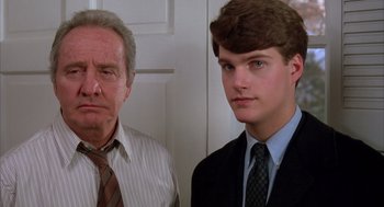 Movie still from “Scent of a Woman” (1992), directed by Martin Brest – A man standing next to another man wearing a suit; Close Up shot, Low angle