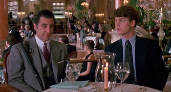 Movie still from “Scent of a Woman” (1992), directed by Martin Brest – Two men sitting at a table in front of a candle; Medium shot, Over the shoulder angle