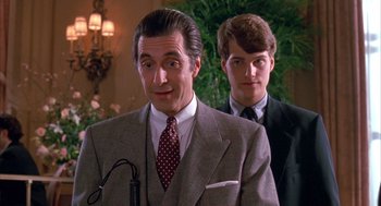 Movie still from “Scent of a Woman” (1992), directed by Martin Brest – A man in a suit and tie standing next to another man in a suit and tie; Close Up shot, Over the shoulder angle