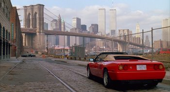 Movie still from “Scent of a Woman” (1992), directed by Martin Brest – A red sports car driving down the street in front of a bridge; Wide shot, Low angle