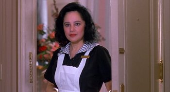 Movie still from “Scent of a Woman” (1992), directed by Martin Brest – A woman standing in front of a door wearing an apron; Close Up shot, Low angle