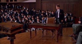 Movie still from “Scent of a Woman” (1992), directed by Martin Brest – A group of people in a room with a podium; Wide shot, High angle