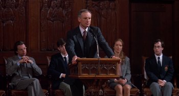 Movie still from “Scent of a Woman” (1992), directed by Martin Brest – A man in a suit is speaking at a lectern; Medium shot, Low angle