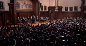 Movie still from “Scent of a Woman” (1992), directed by Martin Brest – A group of men in suits sitting in front of an audience; Extreme Wide shot, High angle