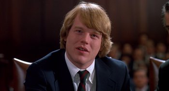 Movie still from “Scent of a Woman” (1992), directed by Martin Brest – A man in a suit and tie sitting in front of a crowd; Close Up shot, Low angle