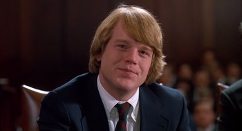 Movie still from “Scent of a Woman” (1992), directed by Martin Brest – A man in a suit and tie sitting in a room; Close Up shot, Low angle