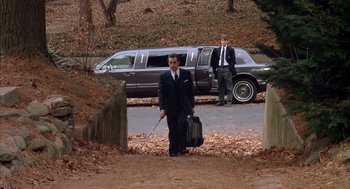 Movie still from “Scent of a Woman” (1992), directed by Martin Brest – A man in a suit and tie holding a suitcase and a bag; Wide shot, High angle