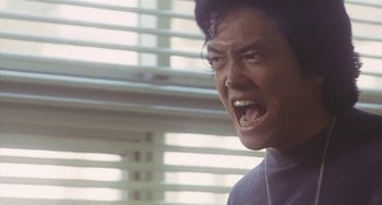 Movie still from “School in the Crosshairs” (1981), directed by Nobuhiko Ôbayashi – An asian man with his mouth wide open; Close Up shot, Low angle