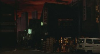 Movie still from “School in the Crosshairs” (1981), directed by Nobuhiko Ôbayashi – People are standing in front of a building at night; Extreme Wide shot, Low angle