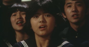 Movie still from “School in the Crosshairs” (1981), directed by Nobuhiko Ôbayashi – A young asian woman with a black and white uniform; Close Up shot, Low angle