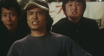 Movie still from “School in the Crosshairs” (1981), directed by Nobuhiko Ôbayashi – Two asian men standing next to each other; Close Up shot, Low angle