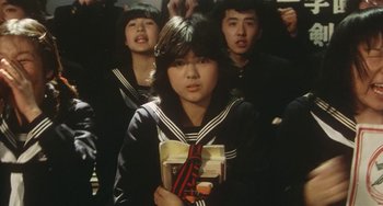 Movie still from “School in the Crosshairs” (1981), directed by Nobuhiko Ôbayashi – A group of young people standing next to each other; Medium shot, High angle