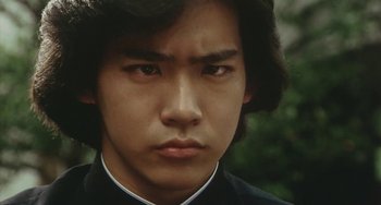 Movie still from “School in the Crosshairs” (1981), directed by Nobuhiko Ôbayashi – A person wearing a suit and tie; Close Up shot, Low angle