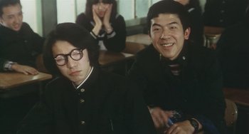 Movie still from “School in the Crosshairs” (1981), directed by Nobuhiko Ôbayashi – A couple of people that are sitting in a room; Medium shot, Low angle