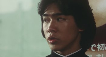 Movie still from “School in the Crosshairs” (1981), directed by Nobuhiko Ôbayashi – A person wearing a black shirt; Close Up shot, Low angle