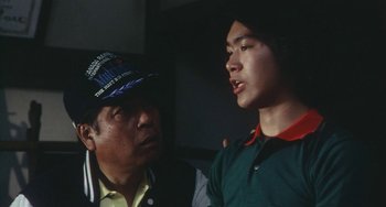 Movie still from “School in the Crosshairs” (1981), directed by Nobuhiko Ôbayashi – Two men talking to each other in a room; Close Up shot, Over the shoulder angle