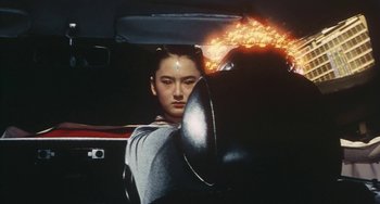 Movie still from “School in the Crosshairs” (1981), directed by Nobuhiko Ôbayashi – A woman sitting in the driver's seat of a car; Close Up shot, High angle