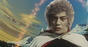 Movie still from “School in the Crosshairs” (1981), directed by Nobuhiko Ôbayashi – A man's face in front of mountains; Close Up shot, Low angle