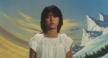 Movie still from “School in the Crosshairs” (1981), directed by Nobuhiko Ôbayashi – A woman in a white dress standing in front of a mountain range; Medium shot, Low angle
