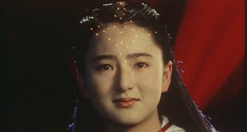 Movie still from “School in the Crosshairs” (1981), directed by Nobuhiko Ôbayashi – A young woman with long black hair and a sparkler on her head; Close Up shot, Low angle