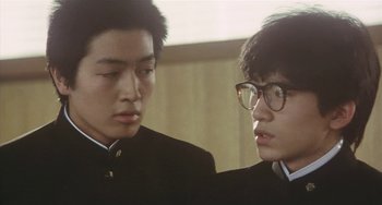 Movie still from “School in the Crosshairs” (1981), directed by Nobuhiko Ôbayashi – Two young men are looking at one another; Close Up shot, Low angle