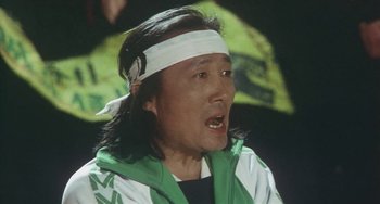 Movie still from “School in the Crosshairs” (1981), directed by Nobuhiko Ôbayashi – A man with a bandage on his head; Close Up shot, Low angle