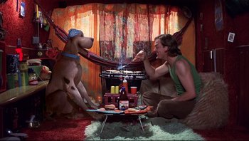 Movie still from “Scooby-Doo” (2002), directed by Raja Gosnell – A man sitting on the ground next to a dog; Wide shot, Low angle