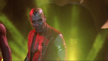 Movie still from “Scooby-Doo” (2002), directed by Raja Gosnell – A man in a red and black outfit is posing for a picture; Medium shot, Low angle