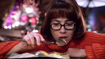 Movie still from “Scooby-Doo” (2002), directed by Raja Gosnell – A woman in a red sweater holding a pair of scissors; Close Up shot, Low angle