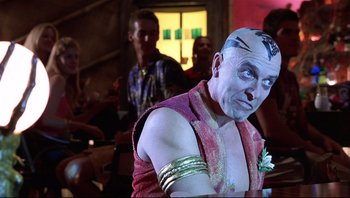 Movie still from “Scooby-Doo” (2002), directed by Raja Gosnell – A man in a purple shirt and a white mask; Medium shot, Over the shoulder angle