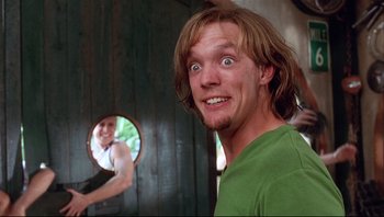 Movie still from “Scooby-Doo” (2002), directed by Raja Gosnell – A young man is looking at himself in the mirror; Medium shot, Low angle