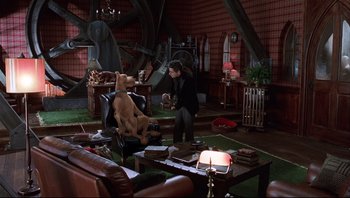 Movie still from “Scooby-Doo” (2002), directed by Raja Gosnell – A man sitting in a room with a dog; Wide shot, High angle