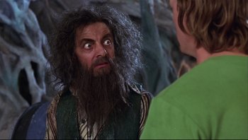 Movie still from “Scooby-Doo” (2002), directed by Raja Gosnell – A man with long hair and a long beard looking at another man; Close Up shot, Over the shoulder angle