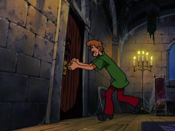 Movie still from “Scooby-Doo on Zombie Island” (1998), directed by Jim Stenstrum – A cartoon of a man holding a key to a door; Wide shot, High angle