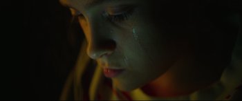 Movie still from “Scrapper” (2023), directed by Charlotte Regan – A child's face with tears in their eyes; Extreme Close Up shot, High angle