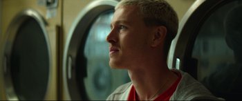 Movie still from “Scrapper” (2023), directed by Charlotte Regan – A person looking up at something; Close Up shot, Low angle