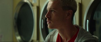 Movie still from “Scrapper” (2023), directed by Charlotte Regan – A person looking up at something; Close Up shot, Low angle