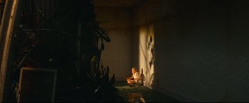 Movie still from “Scrapper” (2023), directed by Charlotte Regan – A baby sitting on the ground in a room; Wide shot, High angle