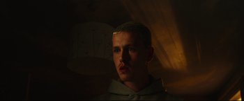 Movie still from “Scrapper” (2023), directed by Charlotte Regan – A man with a beard is looking at the camera; Close Up shot, Low angle