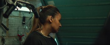 Movie still from “Scrapper” (2023), directed by Charlotte Regan – A person with a ponytail; Close Up shot, Over the shoulder angle