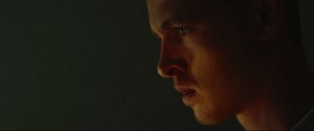 Movie still from “Scrapper” (2023), directed by Charlotte Regan – A man's face in the dark; Extreme Close Up shot, Low angle