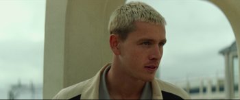 Movie still from “Scrapper” (2023), directed by Charlotte Regan – A person wearing a jacket; Close Up shot, Low angle