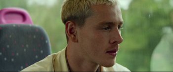 Movie still from “Scrapper” (2023), directed by Charlotte Regan – A person with blonde hair; Close Up shot, Low angle