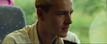 Movie still from “Scrapper” (2023), directed by Charlotte Regan – A person wearing a white shirt; Close Up shot, Low angle