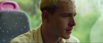 Movie still from “Scrapper” (2023), directed by Charlotte Regan – A person with blonde hair; Close Up shot, Low angle