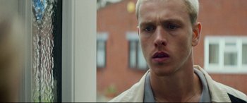 Movie still from “Scrapper” (2023), directed by Charlotte Regan – A person wearing a white shirt; Close Up shot, Low angle