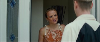 Movie still from “Scrapper” (2023), directed by Charlotte Regan – A woman in an orange and white dress is crying; Close Up shot, Over the shoulder angle