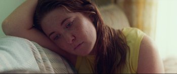 Movie still from “Scrapper” (2023), directed by Charlotte Regan – A person laying on a bed; Close Up shot, High angle