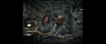 Movie still from “Scrapper” (2023), directed by Charlotte Regan – A man and a woman sitting in front of a computer; Medium shot, Over the shoulder angle