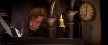 Movie still from “Scrooge” (1970), directed by Ronald Neame – A man sitting in front of a lit candle; Close Up shot, High angle